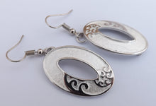 Load image into Gallery viewer, Frosted White &amp; Silver Tone Hollowed Oval Drop Earrings with Ponga Frond Detail
